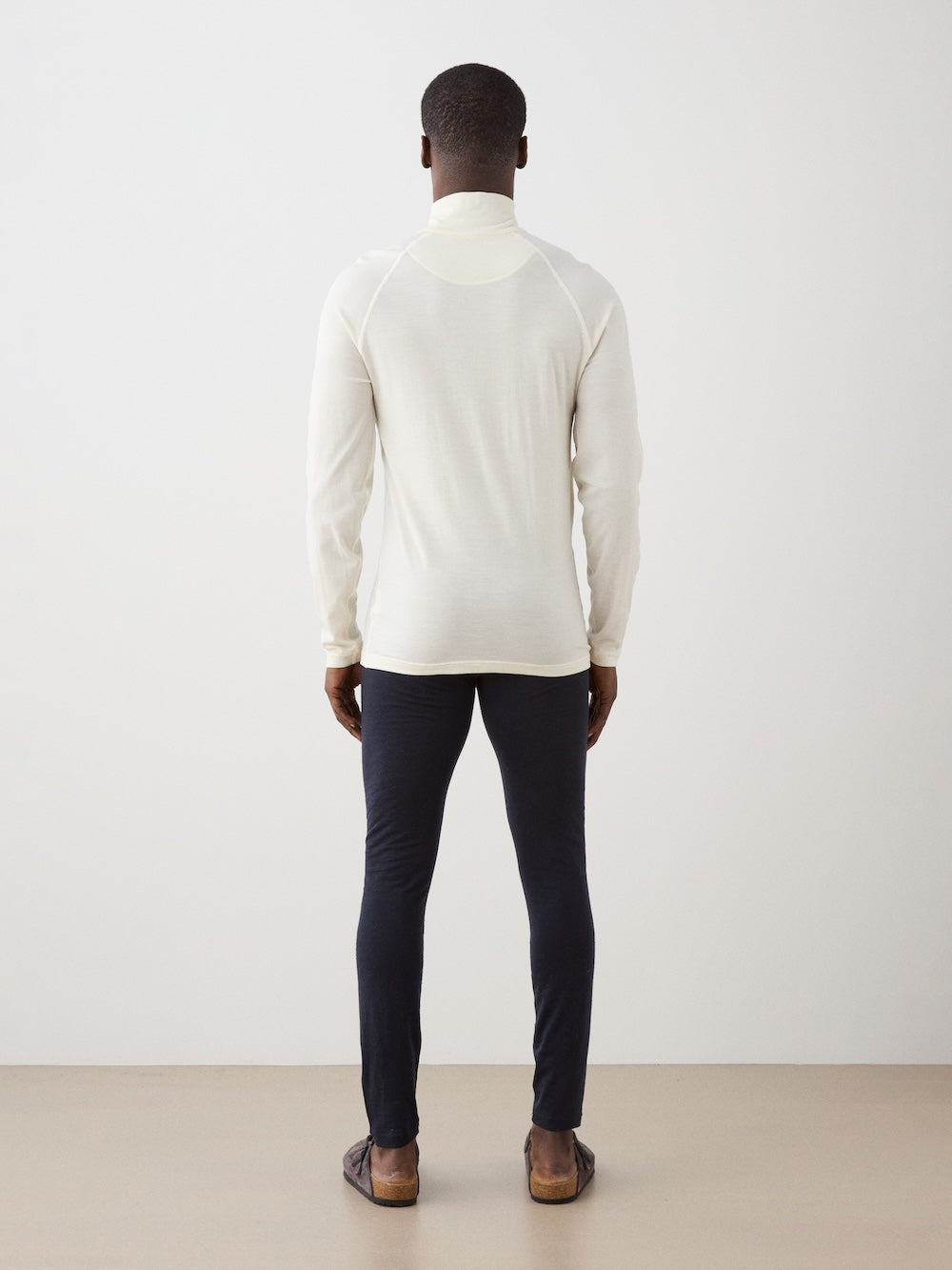 We Norwegians | FW25 | Mens Sno Zip-up_Bright white | A close fit, breathable base layer with a stand collar, 1/4th zipper opening and long sleeves on an off-white background | Back