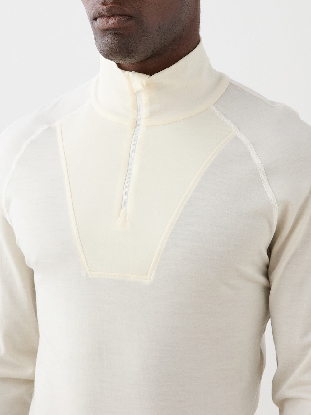 We Norwegians | FW25 | Mens Sno Zip-up_Bright white | A close fit, breathable base layer with a stand collar, 1/4th zipper opening and long sleeves on an off-white background | Close-up