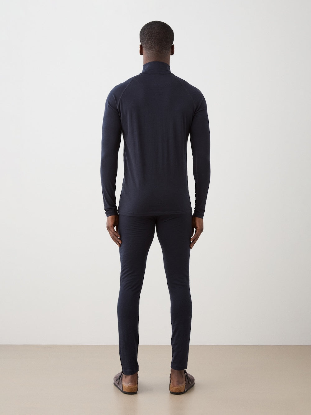 We Norwegians | FW25 | Mens Sno Zip-up_Navy blue | A close fit, breathable base layer with a stand collar, 1/4th zipper opening and long sleeves on an off-white background | Back