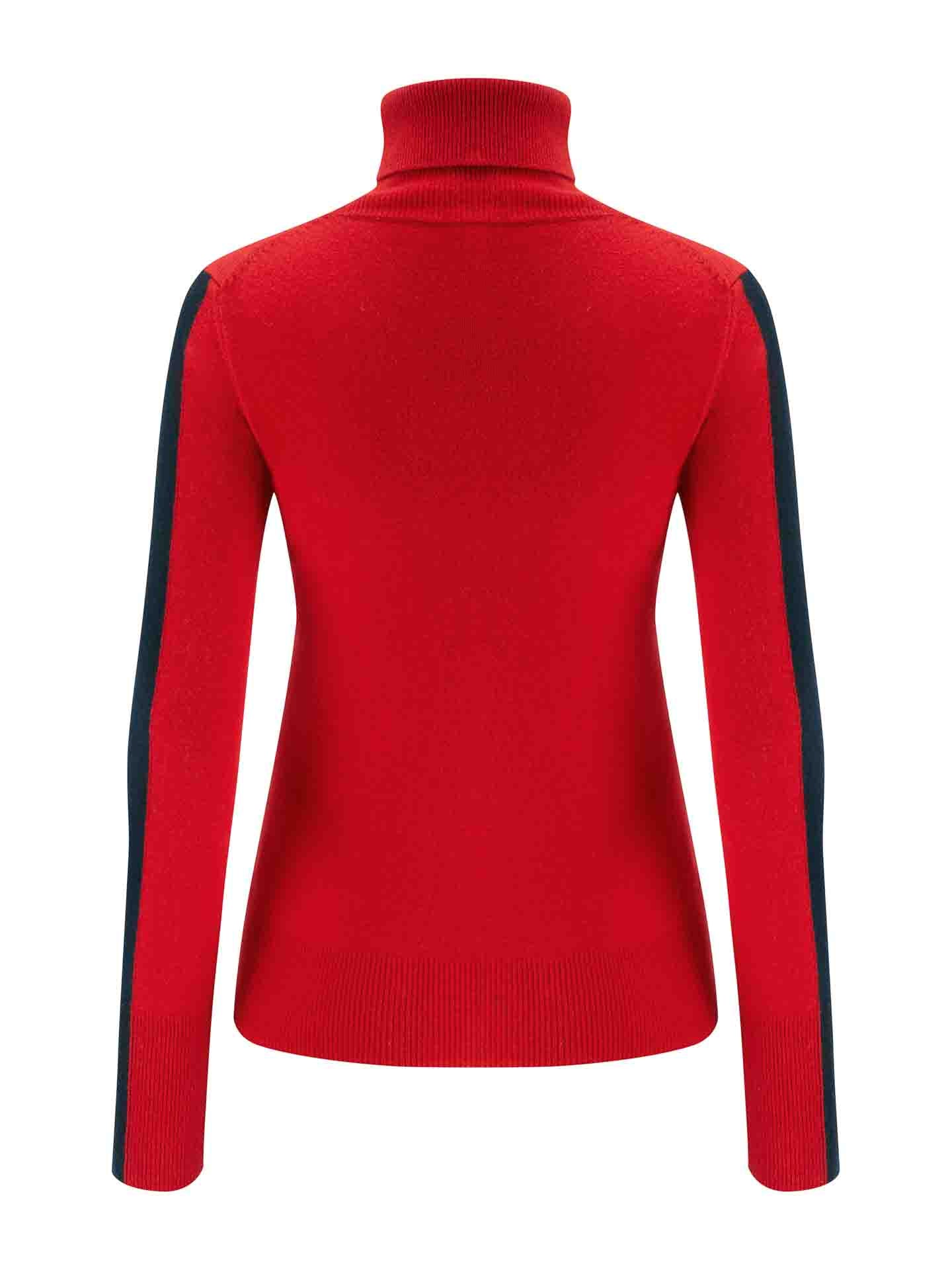 The image shows the back view of a vibrant red, long-sleeved turtleneck sweater from We Norwegians, designed to evoke the 1977 ski fashion. This cozy and warm knit piece, known as the 1977 World Cup Sweater Women Red, features black stripes running down the outer sides of its sleeves.