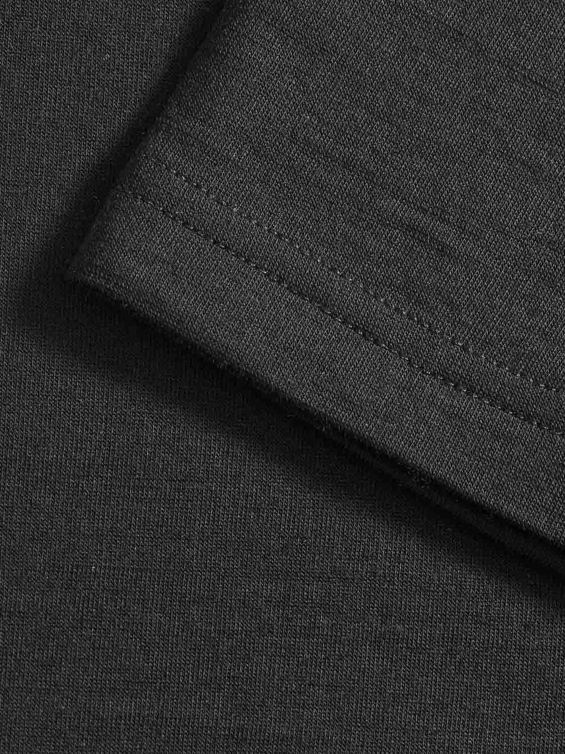 Close-up view of the Salt Classic Top Women Black from We Norwegians, featuring a visible seam. The main focus is on the neatly stitched hem, showcasing the texture and weave of the material. The fabric appears smooth and consistent, indicating good quality craftsmanship—a hallmark of Scandinavian Luxury Essentials.