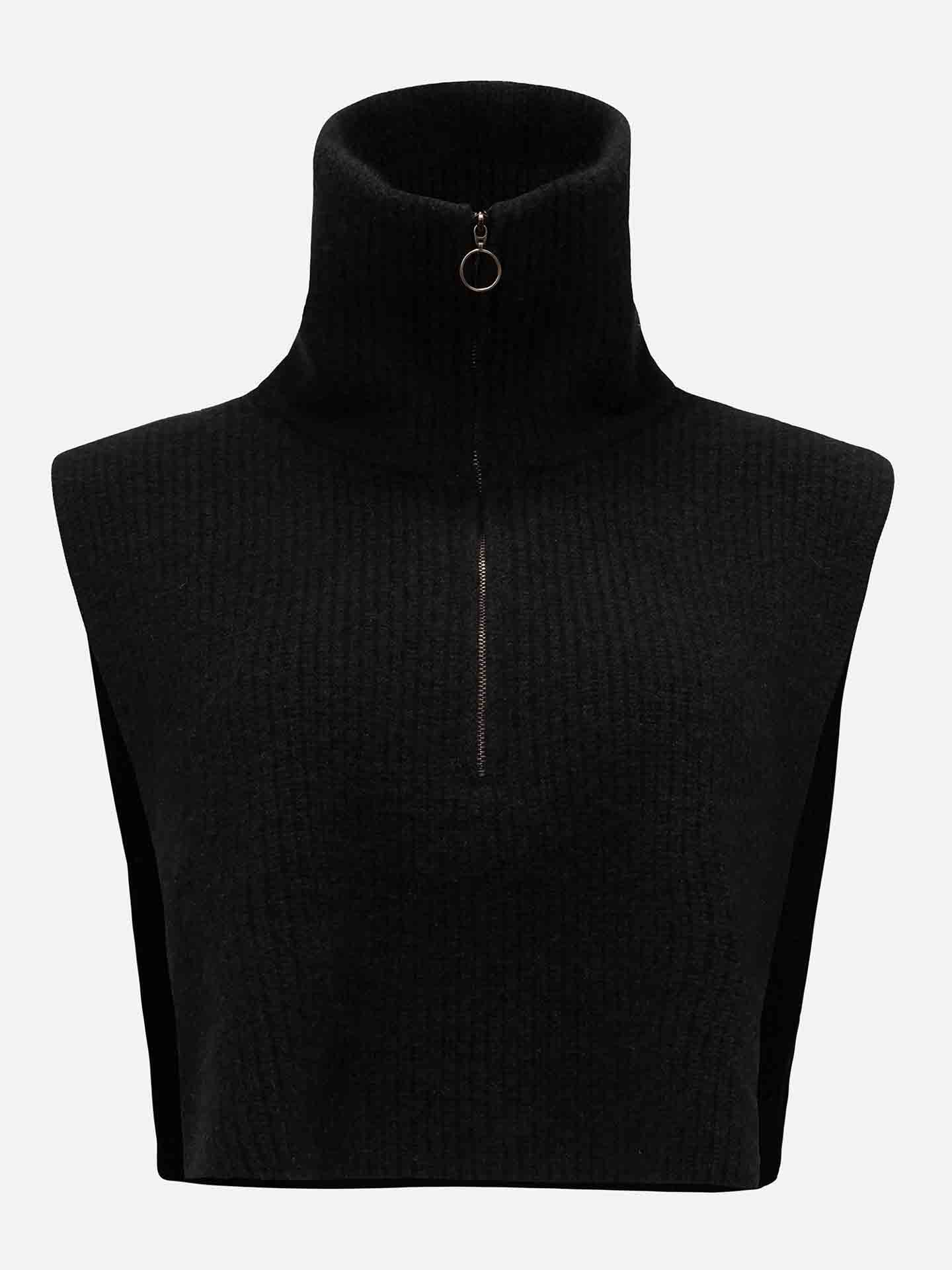 The Blefjell Cashmere Bib Women by We Norwegians is showcased, featuring a black ribbed knit fabric with a sleeveless design, high collar, and a metal half-zip with a circular pull tab, all set against a plain white background.