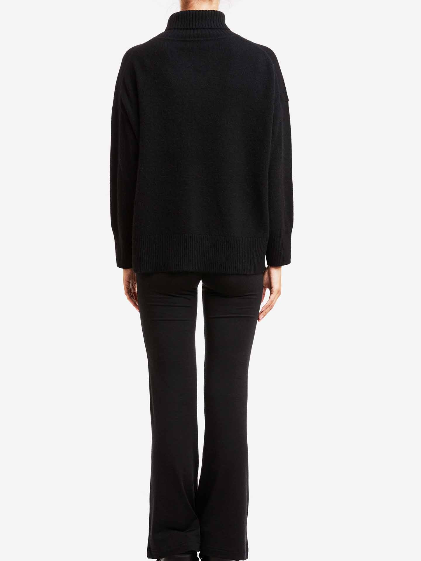 Dressed in We Norwegians' Blefjell Cashmere Sweater and matching pants, one effortlessly embodies luxury fashion. The black long-sleeve turtleneck, highlighted against a plain white background, offers an understated elegance through its timeless style and relaxed fit.