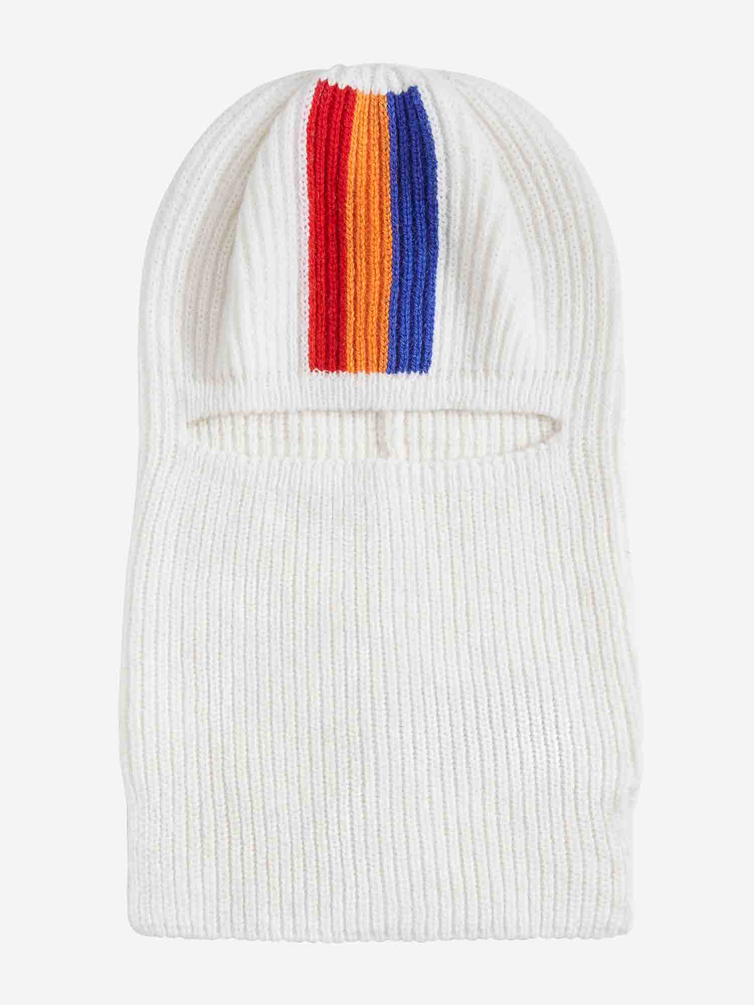 A white knit balaclava with a ribbed texture, featuring vertical stripes in red, orange, and blue from the top to the forehead area. Reminiscent of 70s ski fashion, this Après Ski Balaclava by We Norwegians has a narrow horizontal face opening and is crafted from luxurious merino wool.