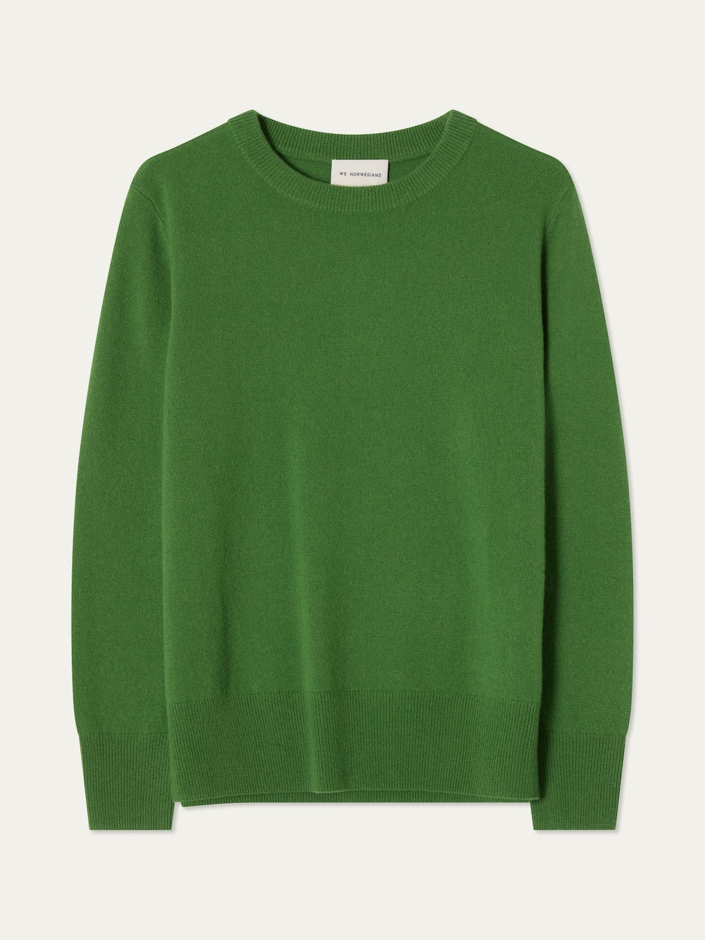 The We Norwegians Blefjell Crewneck Women is a pure cashmere, long-sleeved green sweater with ribbed cuffs, hem, and neckline. Laid flat on a light background, it offers a classic look and luxurious feel.