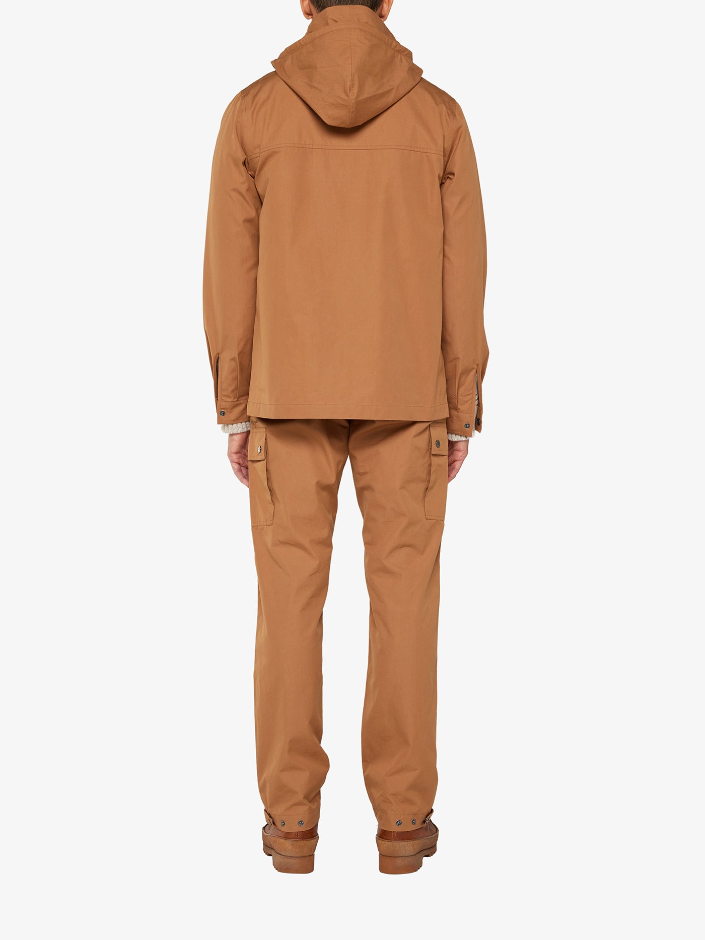 Rear view of a person wearing the matching Lyngen Jacket Men Cinnamon and pants from We Norwegians, crafted from Ventile® cotton fabric. The jacket features a hood, and the pants have side pockets. Designed for outdoor activities or workwear, this outfit boasts weatherproof qualities favored by RAF pilots. Background is plain white.