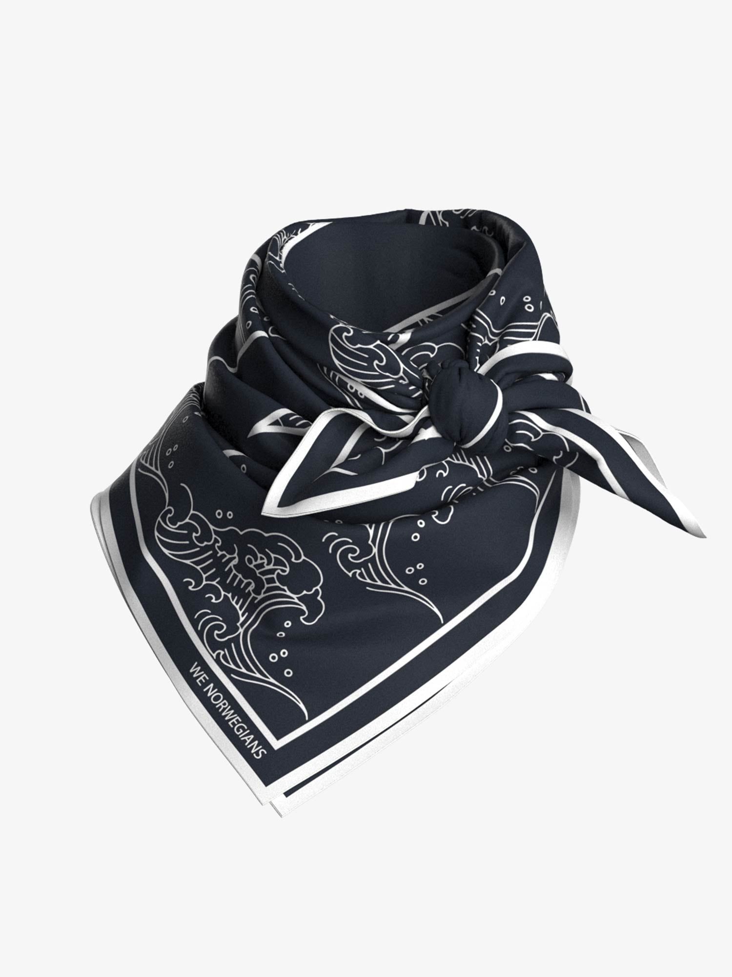 A dark navy blue and white bandana with intricate wave patterns reminiscent of Ukiyo-e art is neatly folded and tied. The bandana, named the "Wavy Silk Scarf Navy Blue" by We Norwegians, has a contrasting white border and features a design that includes a wave motif. The lower corner of the scarf displays the text "We Norwegians.