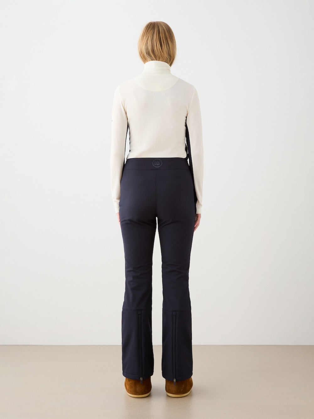 We Norwegians | FW25 | Womens Voss 1/4-Zip_Off white | Model is wearing this light knit top with a stand collar, 1/4th zipper opening and long sleeves - paired with black pants on an off-white background | Back