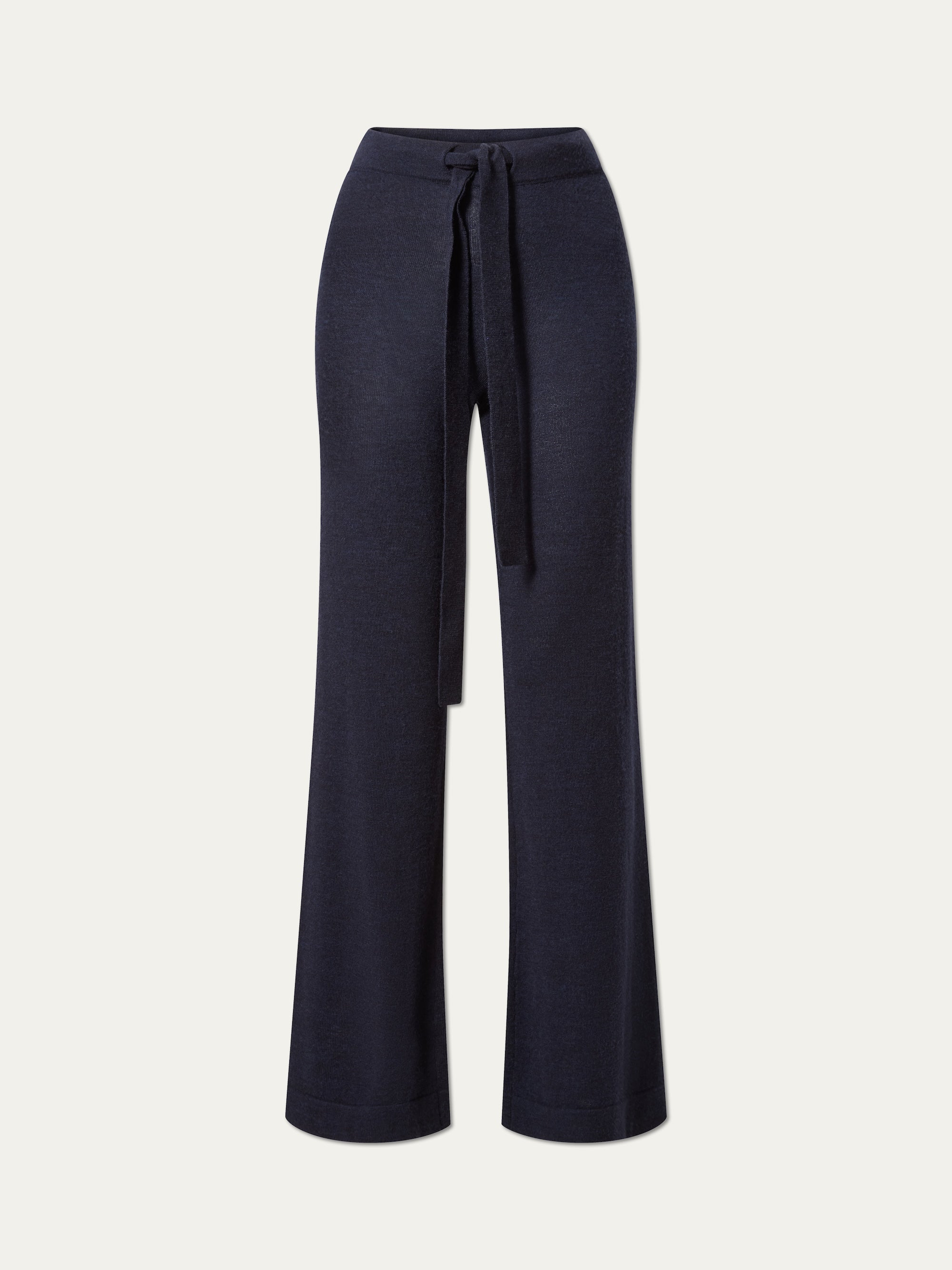 The We Norwegians Geilo Belted Pant Women features wide-leg navy blue 100% merino wool, a high waist, and a matching fabric tie belt, shown on a plain white background.