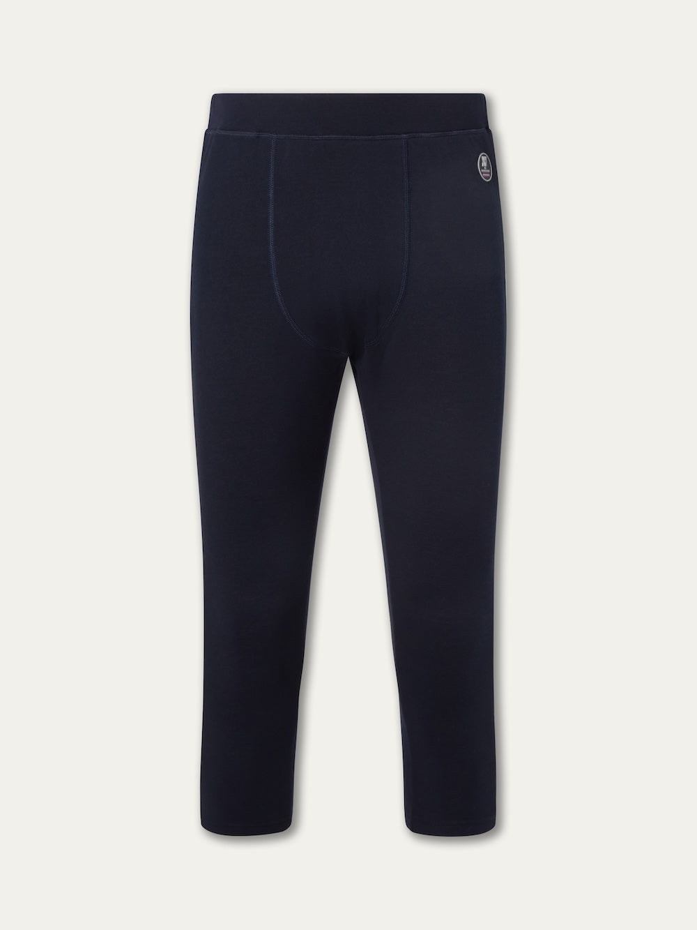 The We Norwegians Voss Long Johns Bottoms Men are navy blue, 3/4 length thermal pants with an elastic waistband and a small circular logo on the upper left hip, ideal as a ski base layer and shown against a light background.