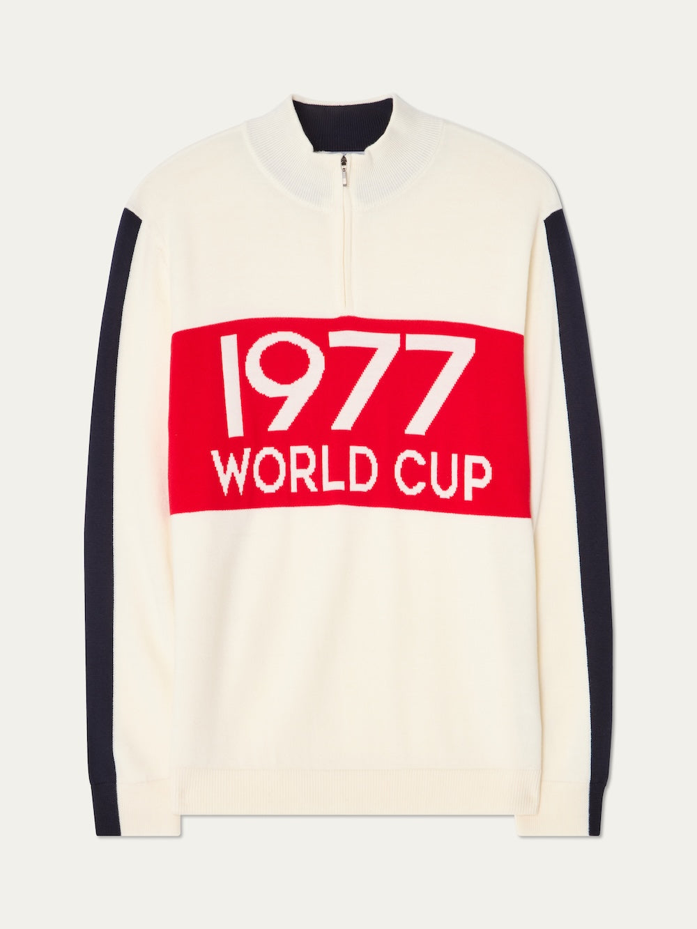 The We Norwegians 1977 World Cup Zipup Men is a white alpine-style sweater with navy sleeves, a zip collar, and a bold red chest panel featuring "1977 WORLD CUP" in large white letters.