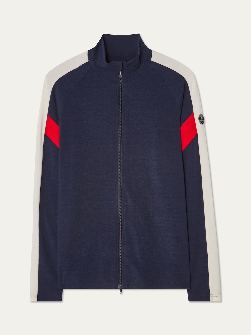 The We Norwegians Zermatt FullZip men’s jacket features a navy body, white sleeves, red diagonal stripes on the arms, and a round logo patch—ideal as a stylish ski mid-layer.