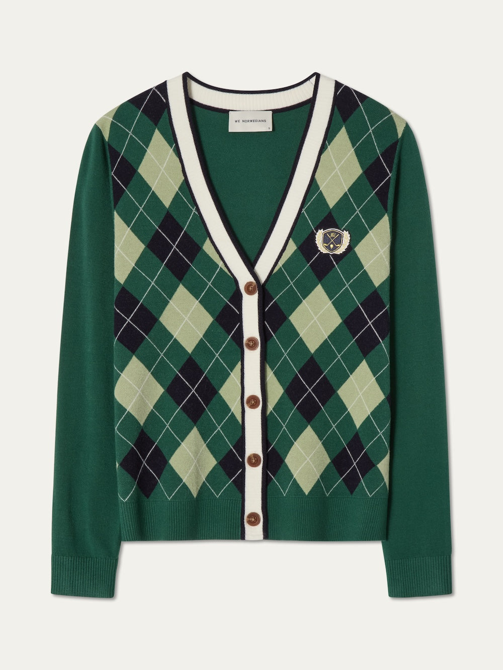 The We Norwegians Fairway Cardigan Women features green argyle knit with light green, navy, and cream diamonds, brown buttons, white trim, and an embroidered crest—perfect for stylish comfort on or off the golf course.