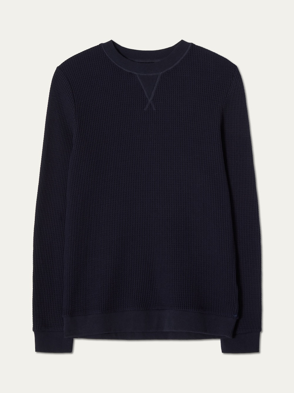 The We Norwegians Waffle Crewneck Men is a relaxed-fit, long-sleeve, dark navy cotton sweater with ribbed collar, cuffs, and hem, shown flat on a plain light background.
