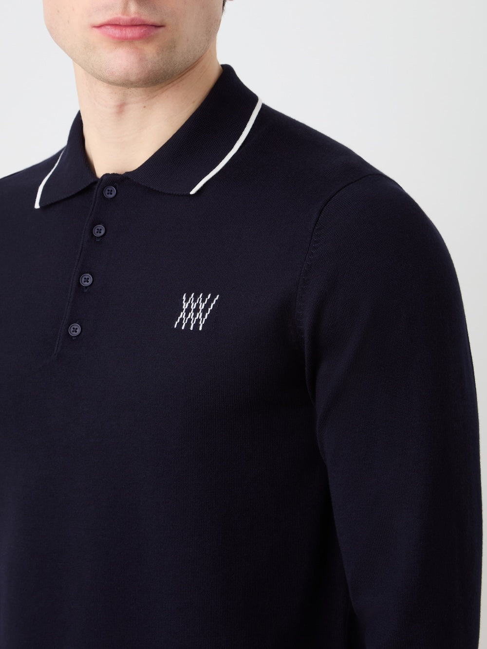Navy blue polo shirt with a small white logo on a light background