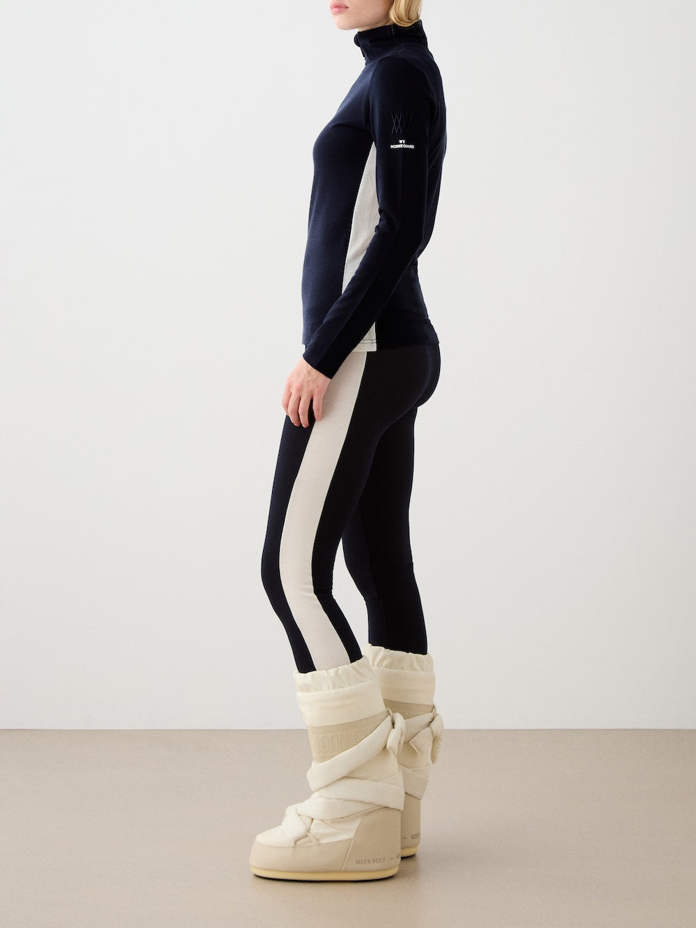 We Norwegians | FW25 | Womens Voss Leggings_Navy blue | Model wearing this fine knitted pair of leggings with contrasting panels on the sides on an off-white background | A perfect base layer or work-out wear | Side