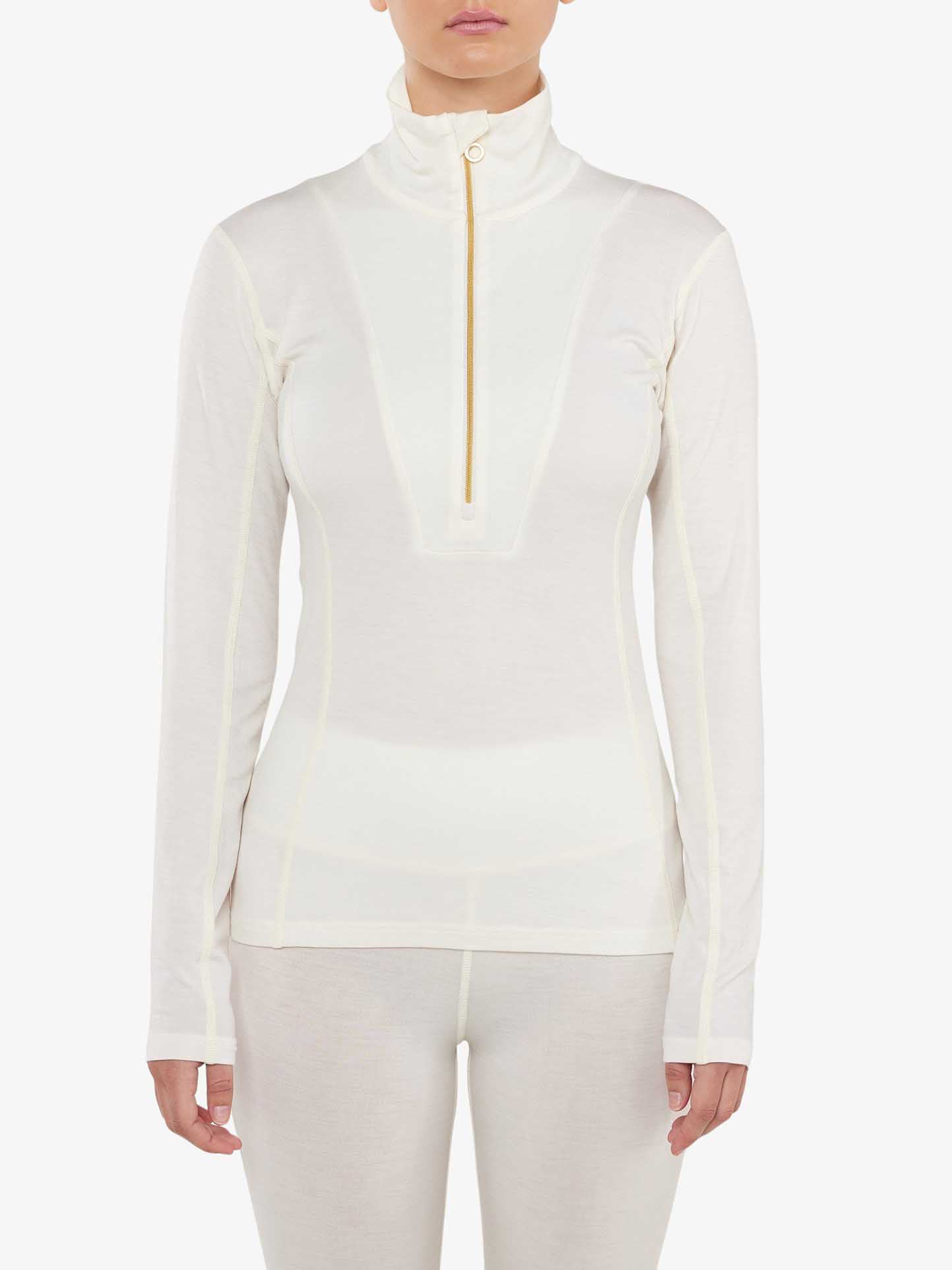 A person wearing the "Sno Merino Zip Up Women" top from We Norwegians, featuring a fitted design with a high collar and half-zip closure, stands against a plain white background. Made of super fine merino wool, this lightweight and slightly sheer top showcases seam detailing. Only the upper torso and arms are visible, embodying Scandinavian luxury base-layers.