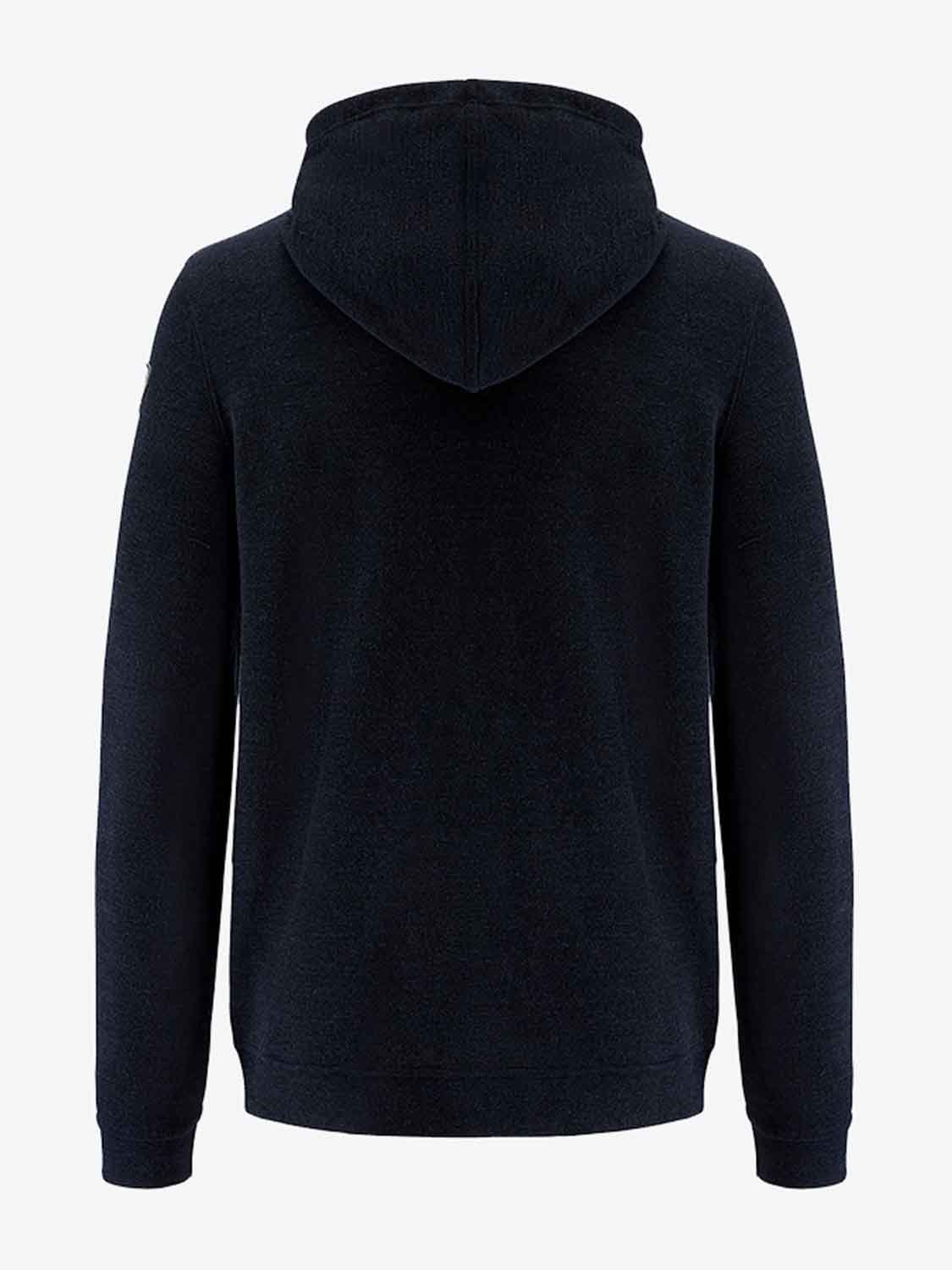 A black hooded sweatshirt is showcased from the back. The Tind Hoodie Men by We Norwegians, made with luxurious Italian Spun Superfine Merino wool, features long sleeves and a minimalistic style devoid of visible logos or patterns. The plain white background accentuates the garment.