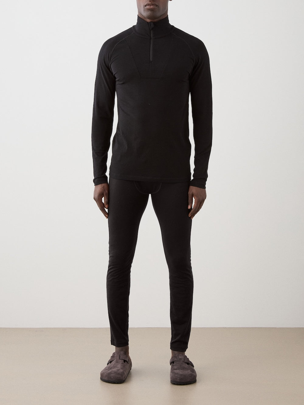 We Norwegians | FW25 | Mens Sno Zip-up_Black | A close fit, breathable base layer with a stand collar, 1/4th zipper opening and long sleeves on an off-white background | Front