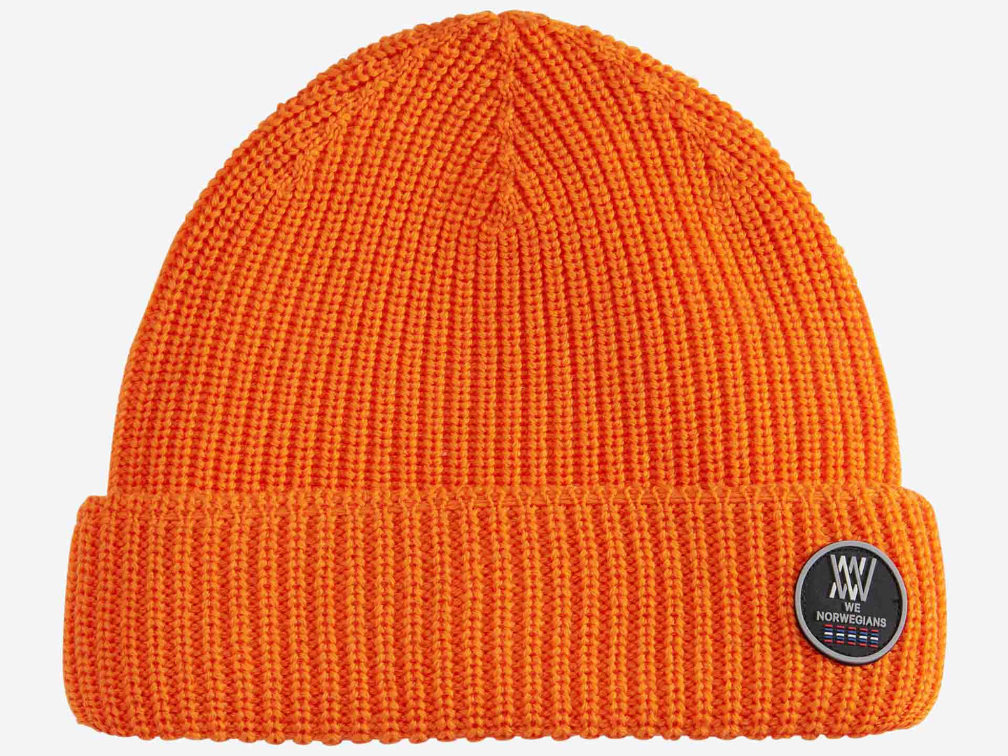 The Kvitfjell Hat is a bright orange knit beanie with a folded brim, crafted from breathable Merino wool. Attached to the brim is a round, black patch featuring white text that reads "We Norwegians" along with a geometric design and stripes in blue, white, and red.