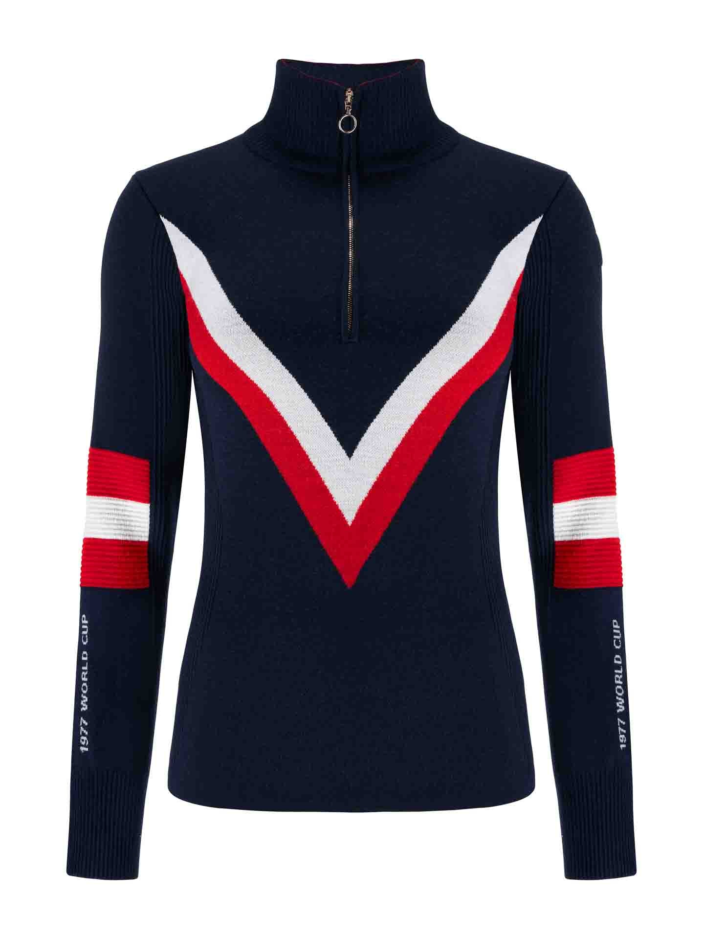 The Hafjell Zip Up Women by We Norwegians is a long-sleeve navy blue sweater made from fine merino wool, featuring a zipper on the high collar and bold red and white V-shaped stripes on the front. The sleeves have matching red and white stripes with text on the left sleeve that reads "1977 WORLD CUP." Crafted by skilled Italian knitters, it's perfect for ski lovers.