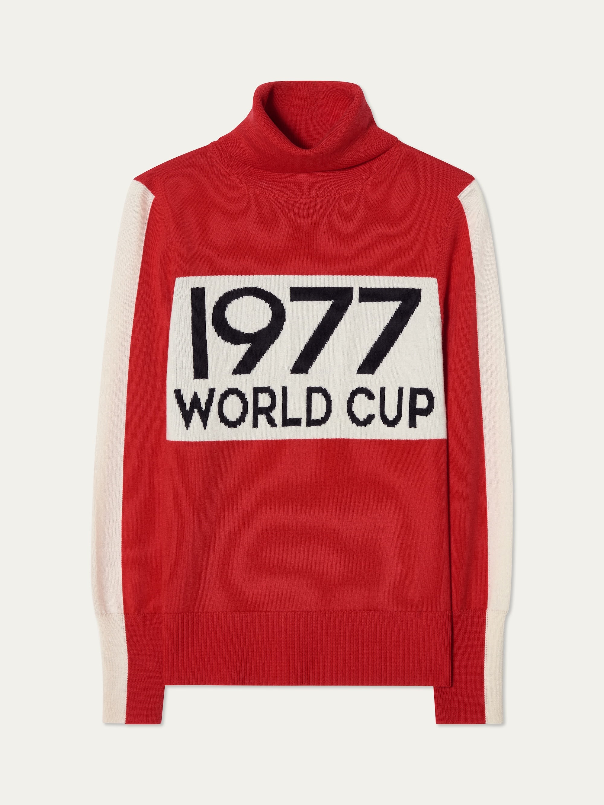 The We Norwegians 1977 World Cup Sweater Women is a red turtleneck inspired by 70s ski fashion, featuring white side panels and a bold front patch with "1977 WORLD CUP" in black letters.