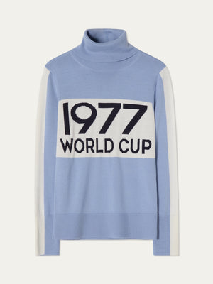 The We Norwegians World Cup Sweater women - Pre Spring 26 is light blue with après-ski style, white sleeve panels, and bold "1977 WORLD CUP" across a white chest block.