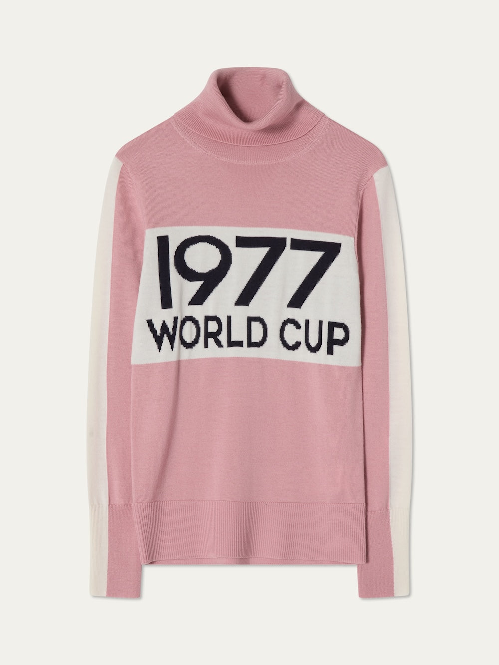 The World Cup Sweater women - Pre Spring 26 by We Norwegians is a pink turtleneck with white sleeve panels and a front patch reading "1977 WORLD CUP," offering retro après-ski style.