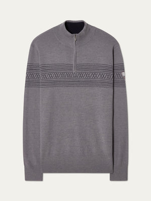 The We Norwegians Signature Zip Up Men is a grey Merino wool sweater with a quarter-zip collar, dark Norwegian Setesdal patterns on the chest and arms, ribbed cuffs and hem, and a subtle logo patch on the left sleeve.