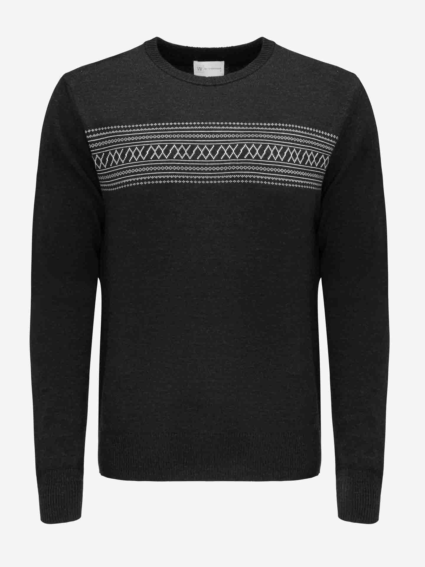 The Signature Crewneck Men from We Norwegians is a black merino wool ski sweater featuring a white and gray geometric pattern across the chest and upper sleeves, inspired by Norwegian heritage. With ribbed cuffs and hem, this sweater ensures both style and warmth on or off the slopes.