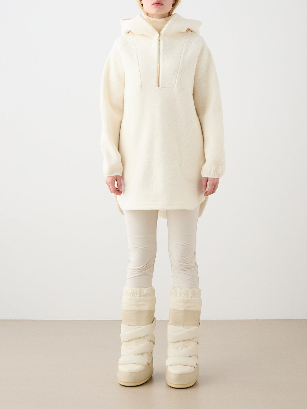 We Norwegians | FW25 | Womens Alta Hoodie_Off white | Person wearing the off-white-colored sweater with a long-sleeve top and pants on a white background | Front