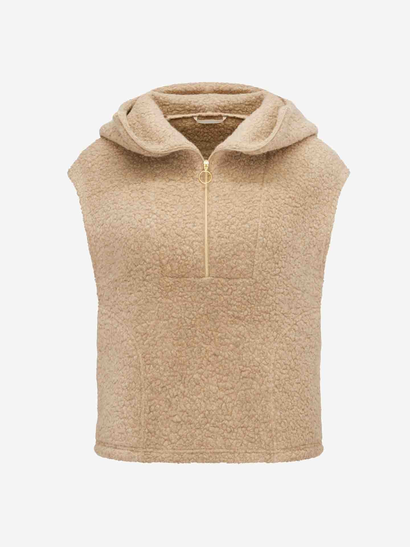 Part of the Alta collection, the We Norwegians' Alta Hooded Vest Women in tan features a sleeveless design with a half-zip front closure and round metal zipper pull. Made from textured fleece and blended with Merino wool for added warmth, this vest offers a relaxed fit that's perfect for layering.