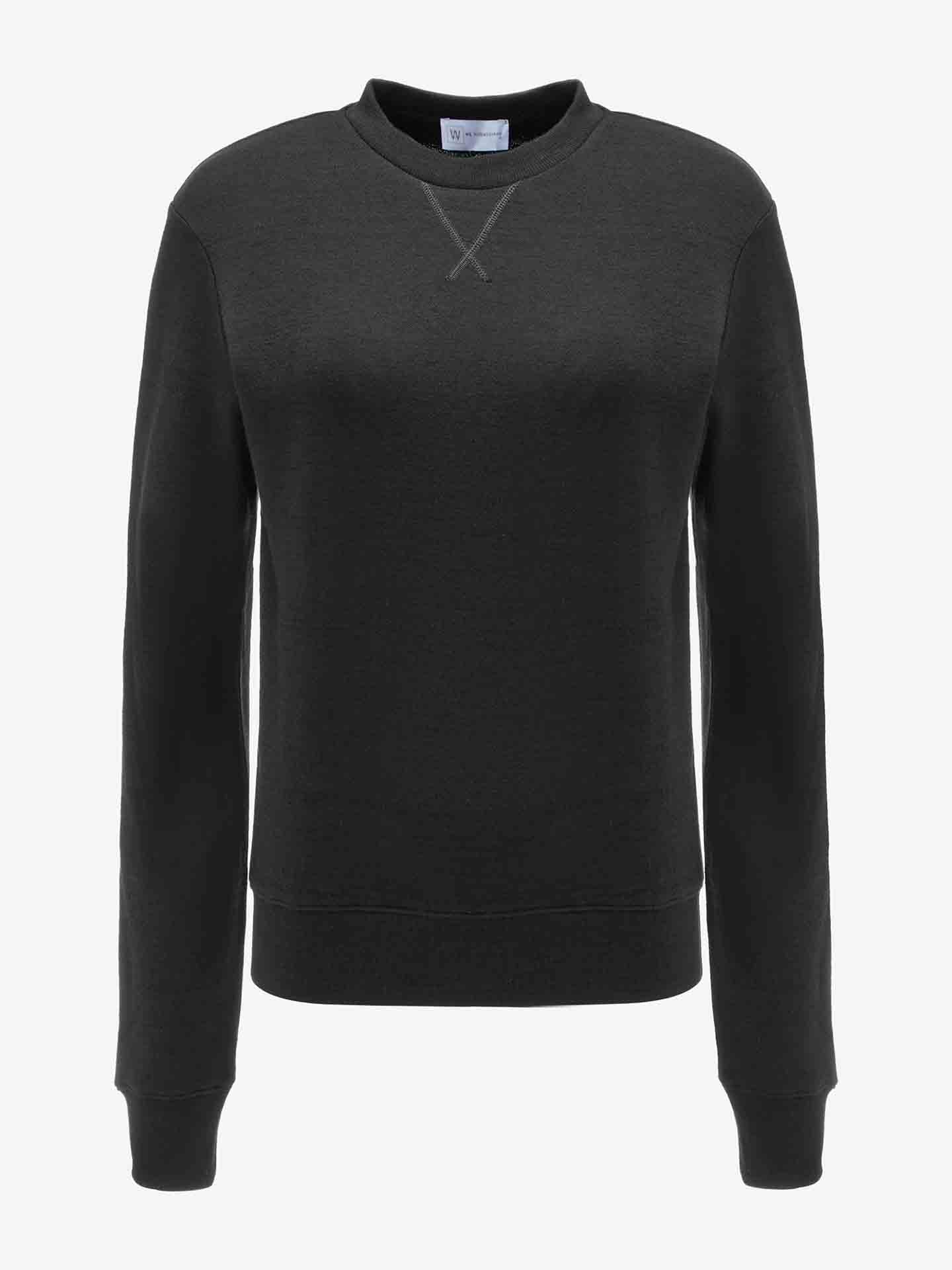 The Tind Crewneck Women Black by We Norwegians is showcased against a white background. This sportswear-inspired sweatshirt features long sleeves, ribbed cuffs and hem, and a small stitched V-detail at the neckline. It boasts a simple and classic design with no visible logos or prints.