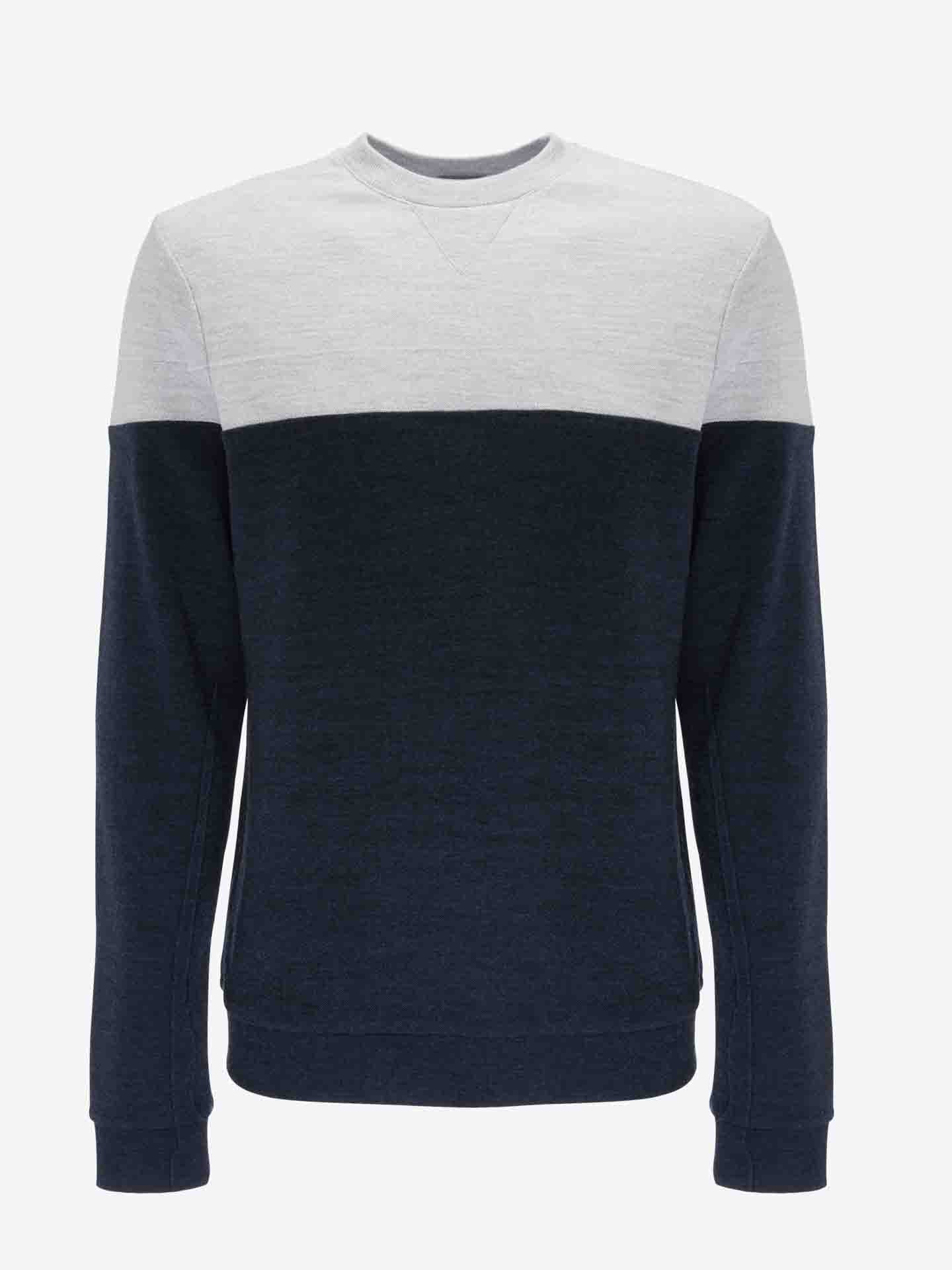 The Tind Crewneck Men by We Norwegians is a long-sleeved sweatshirt featuring a stylish color-block design, making it an ideal match for the Tind Joggers. The light gray upper part, encompassing the shoulders and chest, seamlessly transitions to the navy blue lower section that extends to the cuffs and hem of the sleeves. This sweatshirt is showcased against a white backdrop.