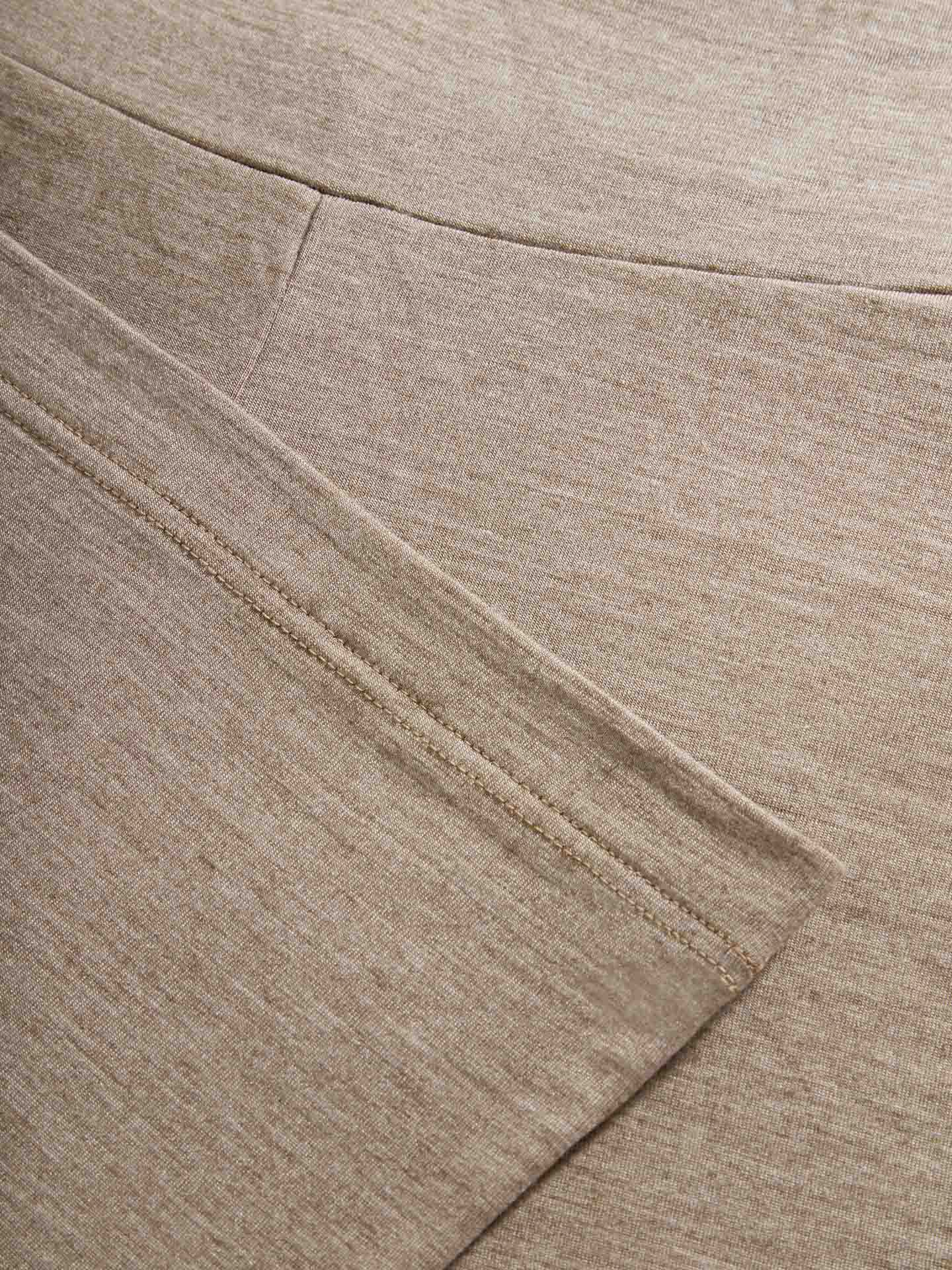 Close-up photo of light brown, textured fabric with visible seams. The fabric is slightly overlapping at the seams, showcasing a detailed view of the material's texture and stitching, resembling the cozy feel of We Norwegians’ Hygge Flared Pant for Women.