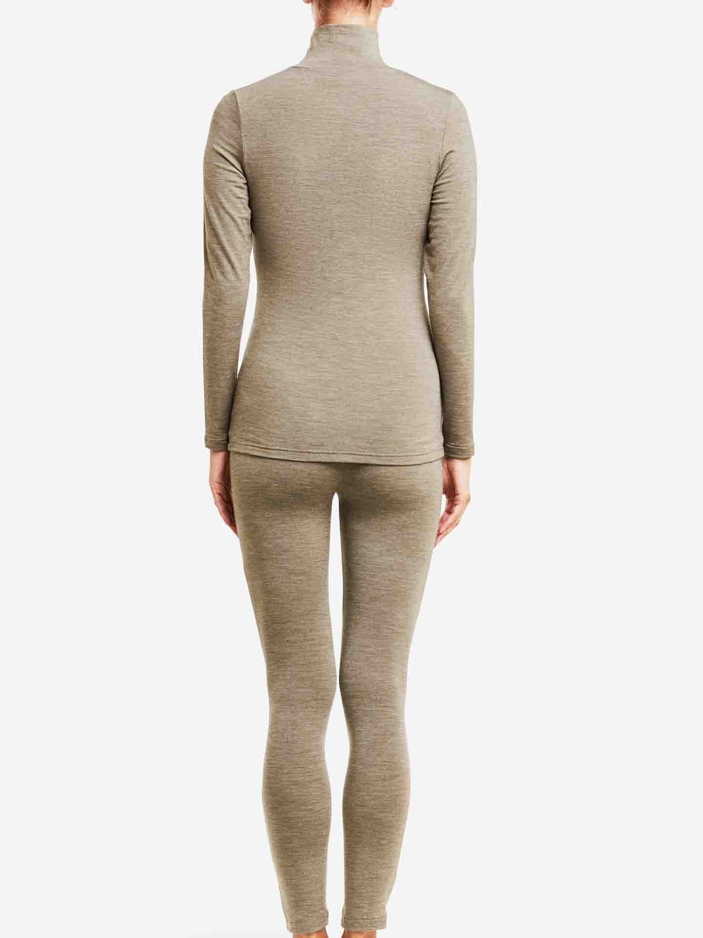 A person stands facing away, wearing a matching light brown, long-sleeved Hygge Zip Up Women top and leggings from We Norwegians, made from merino wool. The outfit appears to be a luxury layering piece that is form-fitting, with the background plain and white. The person’s arms hang naturally by their sides.