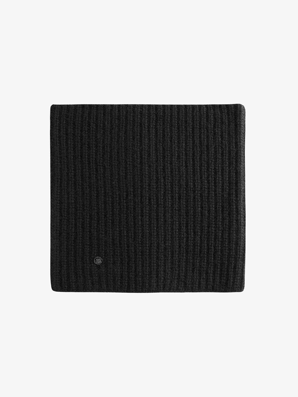 A close-up of the luxurious dark gray Blefjell Cashmere Neckwarmer by We Norwegians is shown on a plain white background. A small circular emblem is visible on the cashmere fabric, adding a subtle detail to this ribbed knitwear piece.