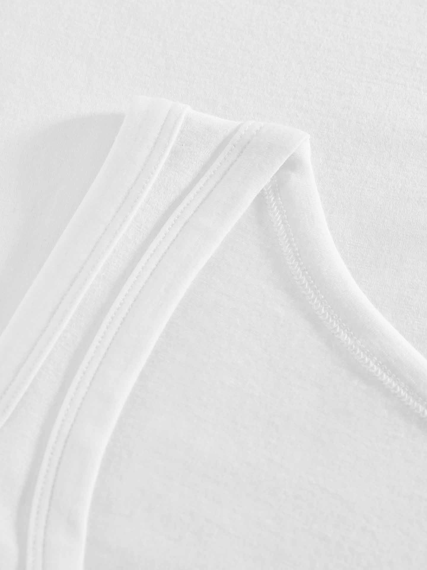 Close-up image of the Sno Merino Tank Top Women by We Norwegians, showing the neckline and shoulder strap. The soft and lightweight fabric of super fine merino wool showcases visible stitching along the edges. Featuring a fitted shape, this Scandinavian luxury base-layer rests on a plain white surface.