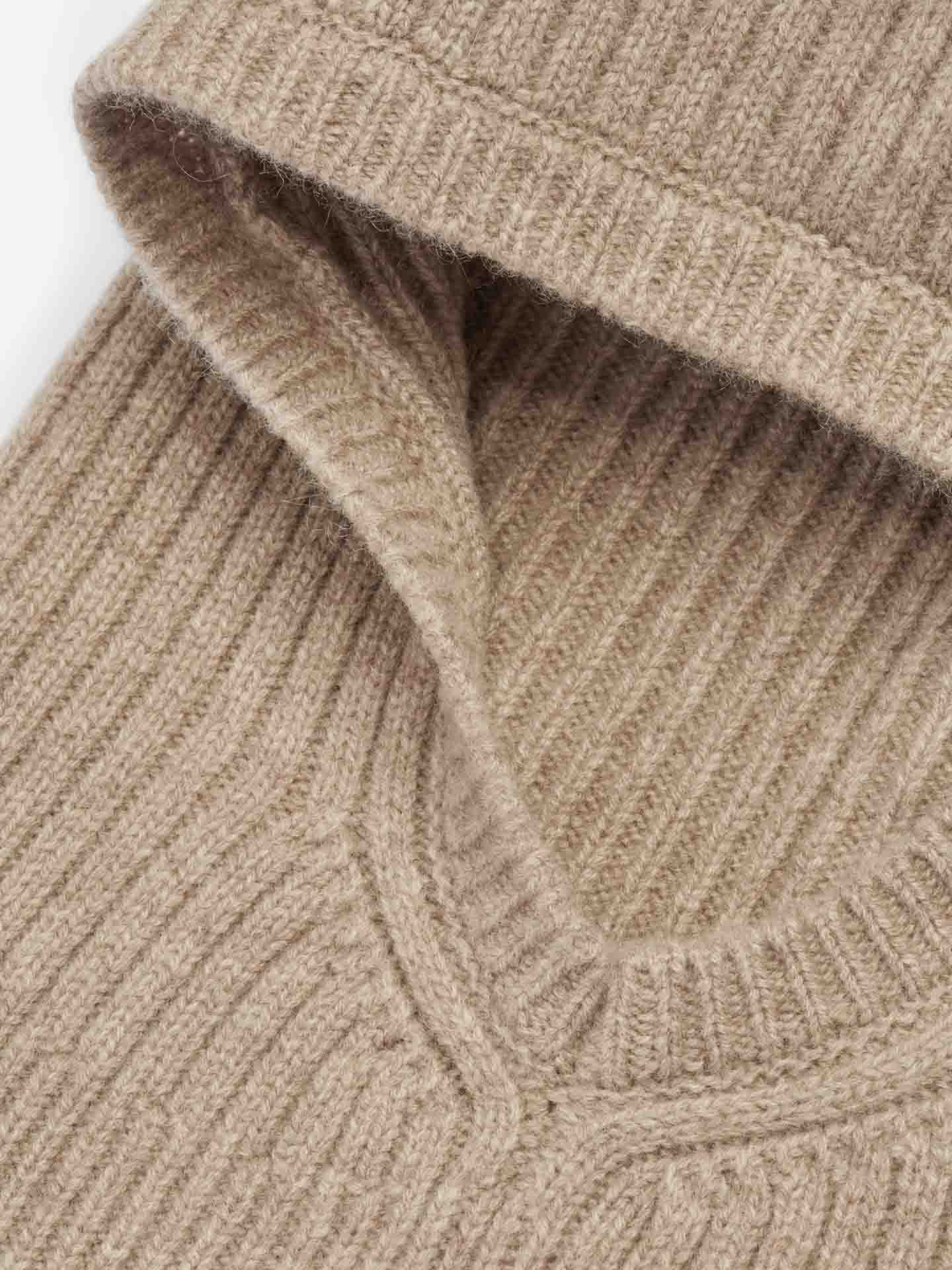 Close-up image of a beige Blefjell Balaclava for women by We Norwegians with a fold-over turtleneck. The texture of the knit fabric, featuring a 1/2 cardigan stitch, is clearly visible, showcasing its soft and cozy cashmere appearance.