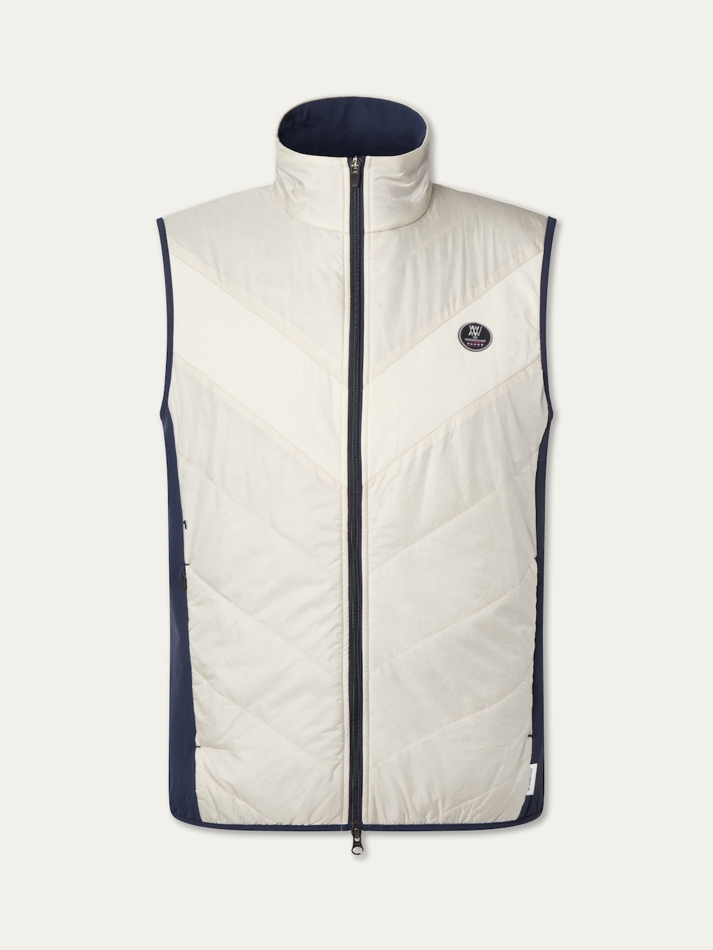 The We Norwegians Beito Vest Men is a sleeveless puffer with a high collar, front zipper, white and navy color blocking, chevron stitching, and a small circular logo—ideal for performance layering in cool weather.