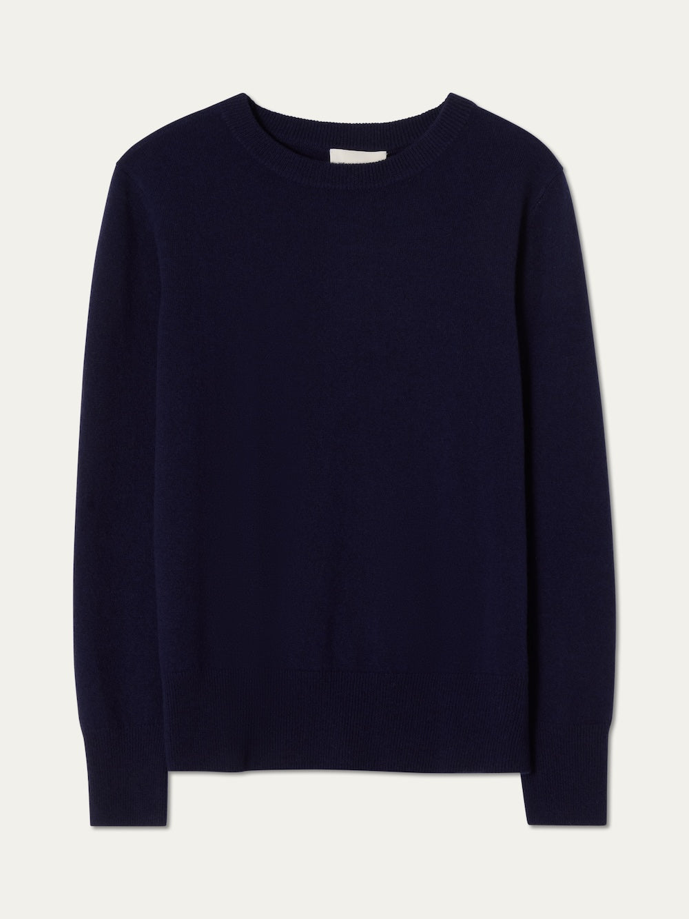 The We Norwegians Blefjell Crewneck Women – Pure Cashmere is a dark navy, long-sleeve women’s sweater with a classic design, ribbed cuffs, hem, and collar. Made from 100% cashmere and shown laid flat on a light background.