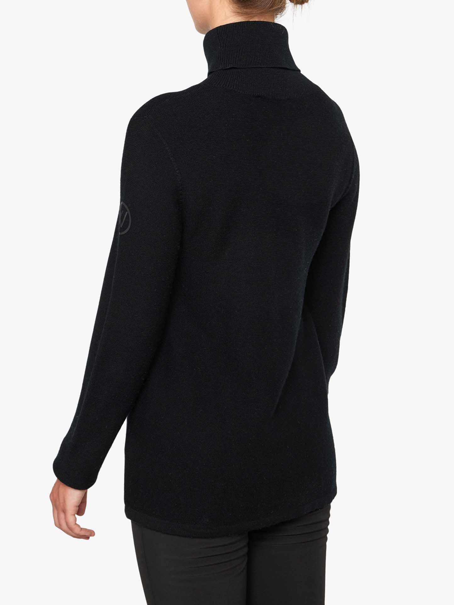 A person is seen from the back, wearing We Norwegians' Uvdal Rollneck Women, a long-sleeved, ribbed roll neck black sweater made of Fine Merino Wool, along with black pants. The plain white background highlights the outfit.