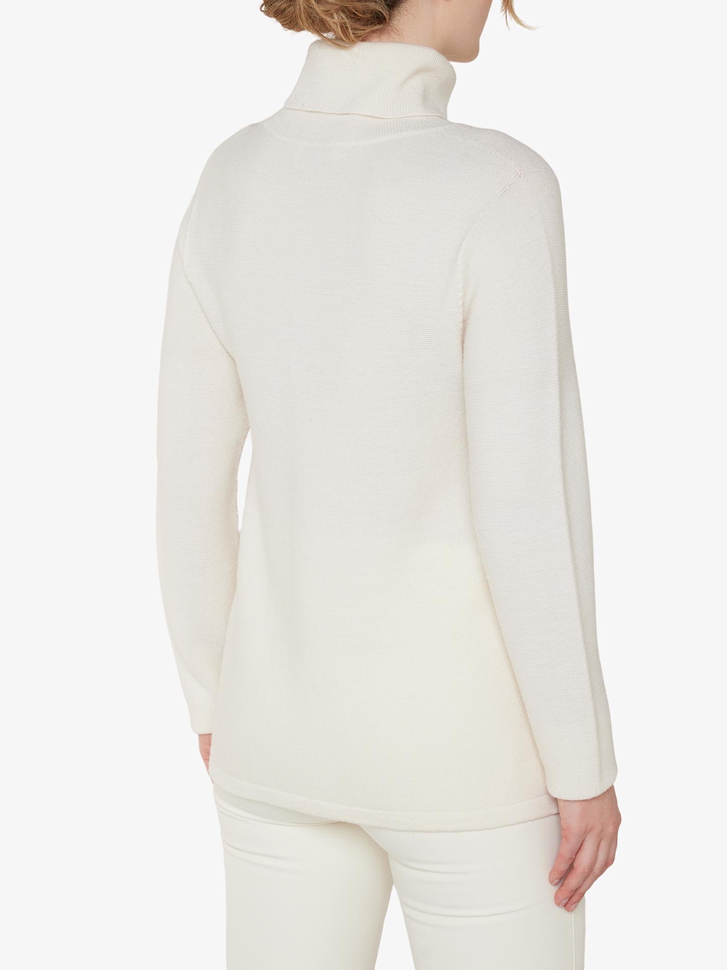 Rear view of a person wearing an off-white Uvdal Rollneck Women sweater by We Norwegians, crafted from fine Merino wool and paired with matching off-white pants. The plain white background accentuates the minimalist outfit and style. The sweater's ribbed roll neck complements the person's light brown hair styled in loose waves.