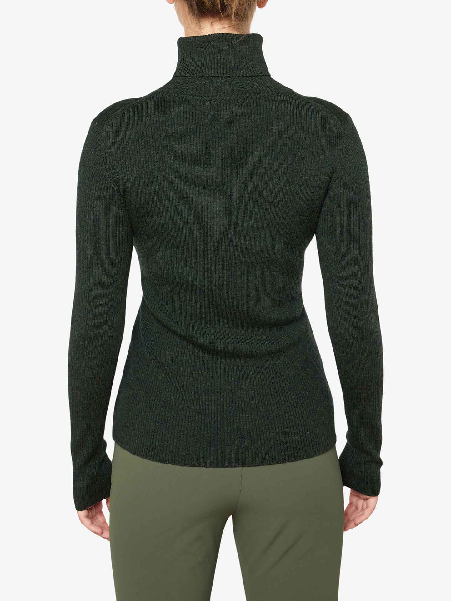 A person wearing the We Norwegians Signature Rollneck Women in dark green and light green pants is shown from the back. The top, made of fine Merino wool, features a ribbed texture and long sleeves. The background is plain white.