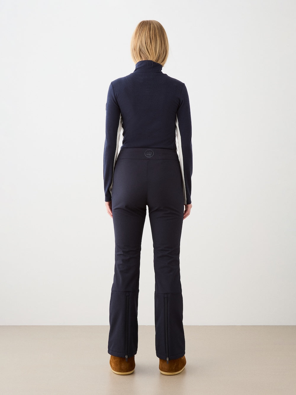 We Norwegians | FW25 | Womens Voss 1/4-Zip_Navy blue | Model is wearing this light knit top with a stand collar, 1/4th zipper opening and long sleeves - paired with black pants on an off-white background | Back