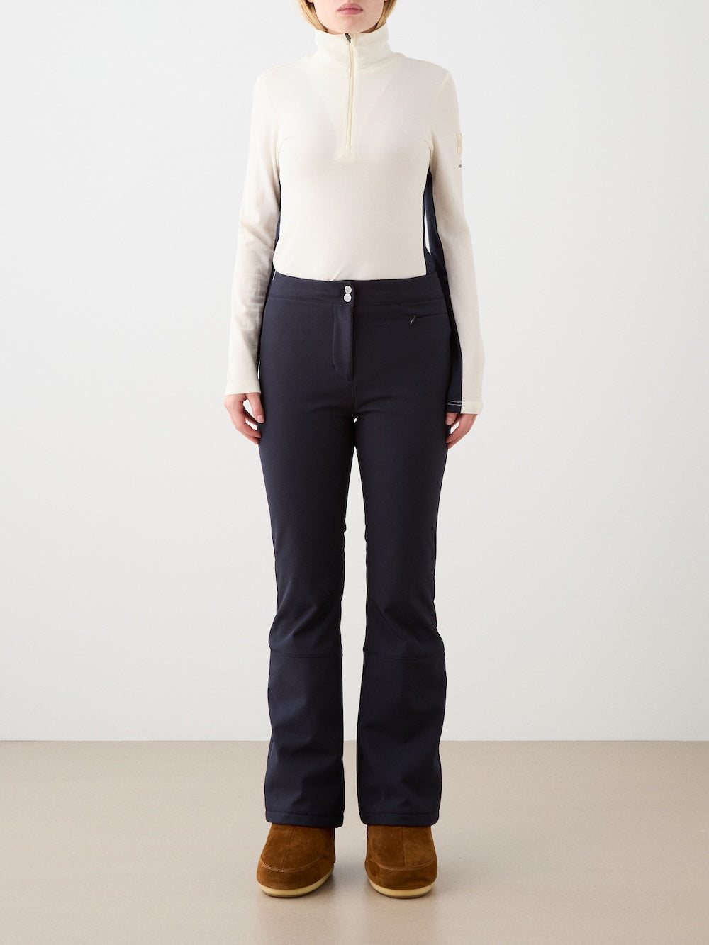 We Norwegians | FW25 | Womens Voss 1/4-Zip_Off white | Model is wearing this light knit top with a stand collar, 1/4th zipper opening and long sleeves - paired with black pants on an off-white background | Front