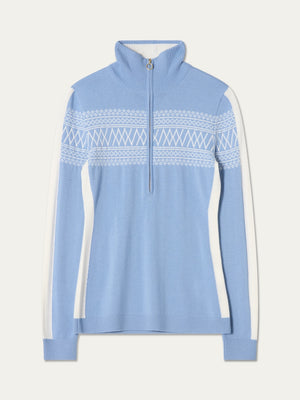 The We Norwegians Signature 1/4-Zip Women is a light blue pullover sweater with a classic Setesdal pattern of white geometric designs across the chest, complemented by white side panels, a signature 1/4-zip collar, and long sleeves.