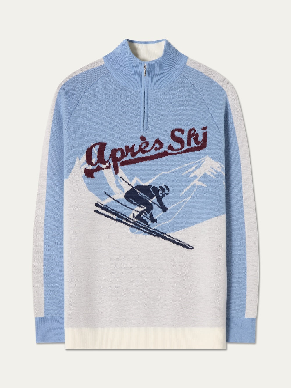 The Afterski Sweater Men by We Norwegians is a light blue and cream vintage-style ski sweater with a half-zip collar, featuring a skier graphic on snowy mountains and “Après Ski” in red script across the chest.