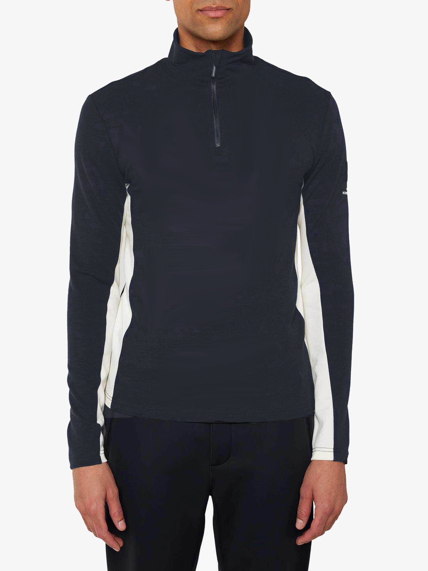 A person wearing a black We Norwegians Voss 1/4-Zip Men long-sleeve athletic top made from superfine Merino wool with color block panels, paired with black pants. The individual stands facing forward with arms relaxed at their sides against a plain white background.