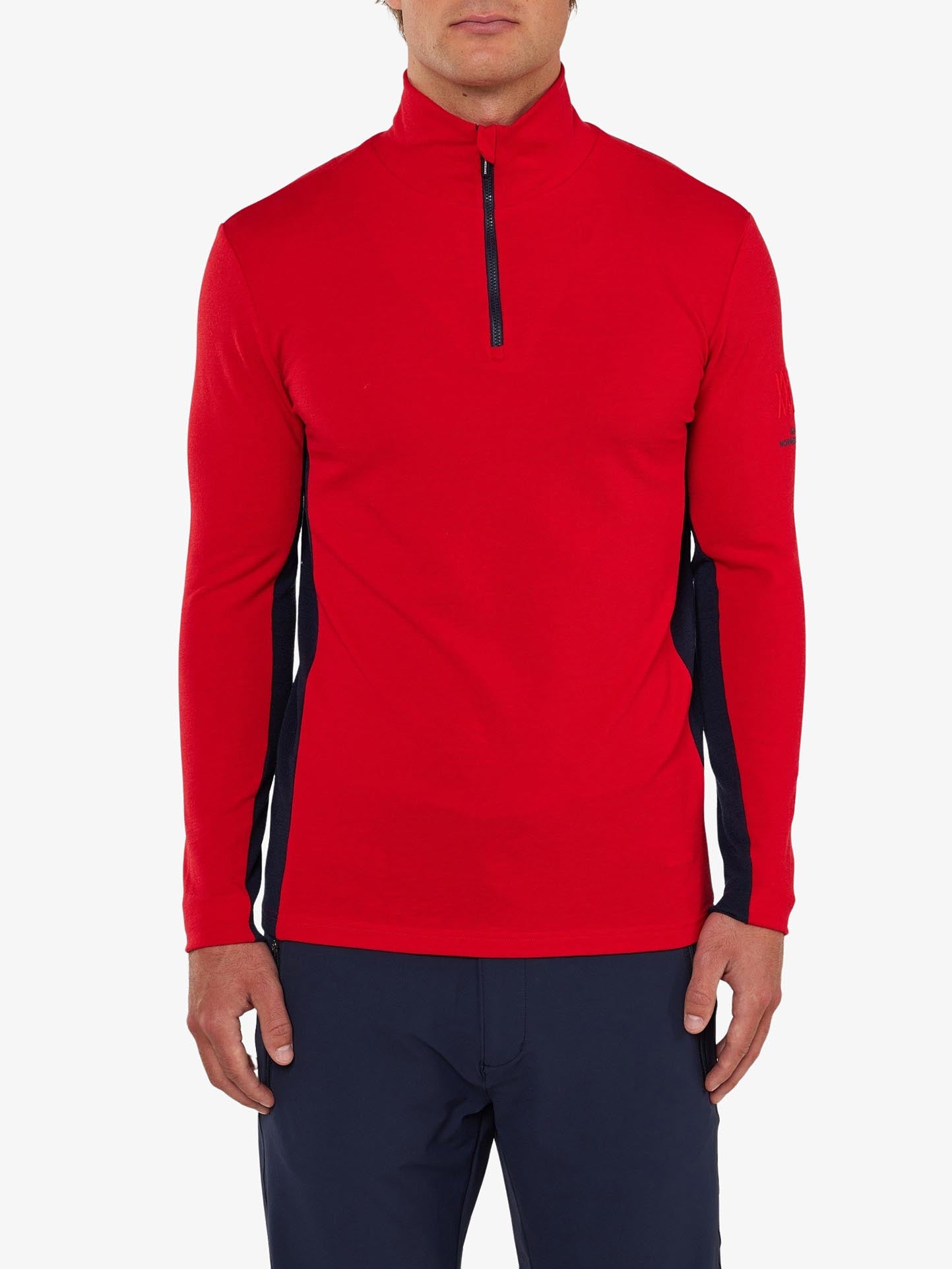 An individual is dressed in a long-sleeve, high-collar Voss 1/4-Zip Men by We Norwegians, made from Superfine Merino wool. The top features color block panels in black on the sides and sleeves and is a striking shade of red. The person complements the look with navy blue pants against a plain white background.